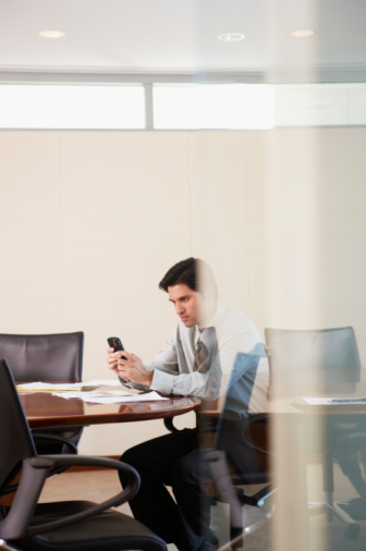 Businessman Using PDA in Conference Room