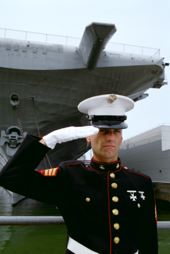 Marine saluting by the Intrepid battleship