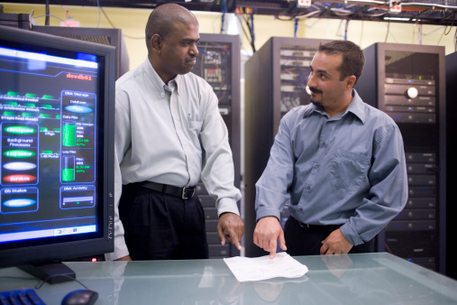 Two technicians standing in front of a network servers