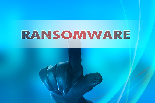 Ransomware concept with hand wearing black glove pressing red bu