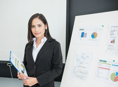 Smiling businesswoman crossed arm with chart background